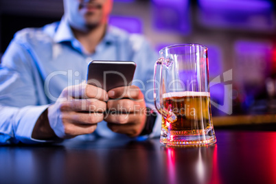 Man using mobile phone at bar counter