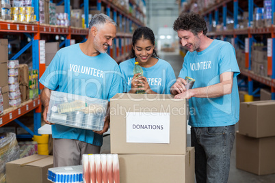 Happy volunteers are looking inside a donations box