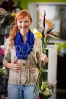 Smiling female florist trimming flower stem