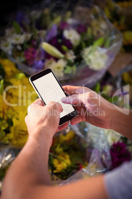 Male florist text messaging on mobile phone