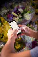 Male florist text messaging on mobile phone