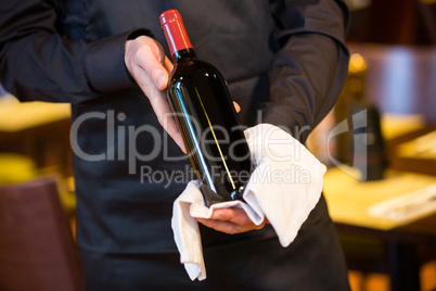 Waiter holding a bottle of red wine