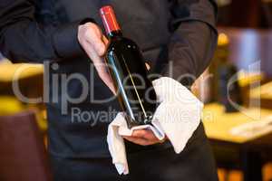 Waiter holding a bottle of red wine