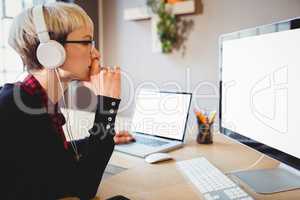 Female graphic designer working on computer and laptop