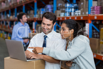 smiling workers pointing at laptop