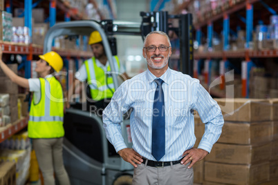 Portrait of manager is smiling and posing with hands on hips