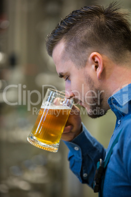 Close-up of brewer testing beer