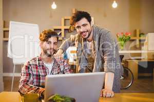 Graphic designer using laptop with his coworker