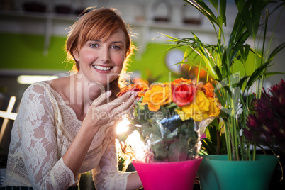 Portrait of female florist touching rose flowers