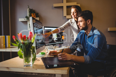 Woman showing her colleague something on the screen