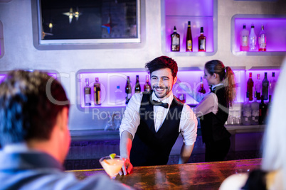 Waiter serving cocktail