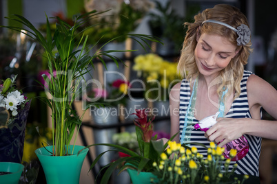 Female florist spraying water on flowers