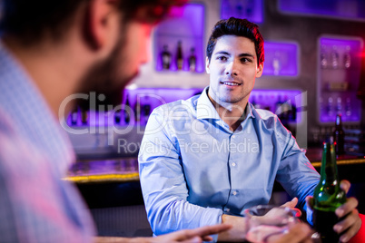 Friends interacting with each other at bar counter while having