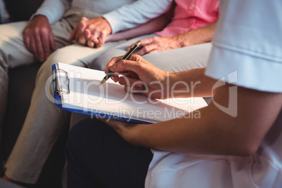 Nurse writing on clipboard