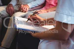 Nurse writing on clipboard