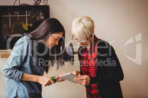 Female graphic designers having discussion on digital tablet