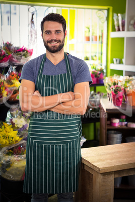 Male florist with arms crossed in his flower shop