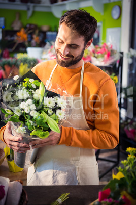 Male florist holding flower bouquet at flower shop
