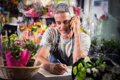 Male florist taking order on mobile phone