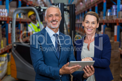 Portrait of happy managers holding a tablet and looking the came