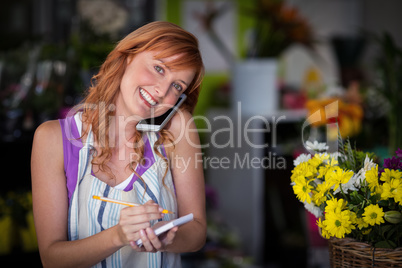 Female florist taking an order on mobile phone