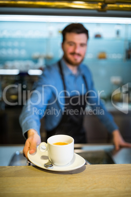 Waiter offering cup of coffee