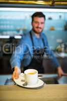 Waiter offering cup of coffee