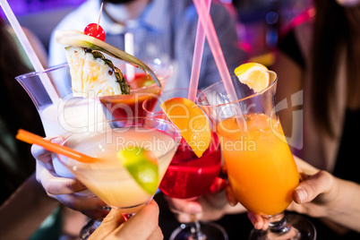 Group of friends toasting cocktail at bar counter