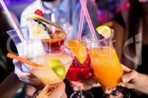 Group of friends toasting cocktail at bar counter