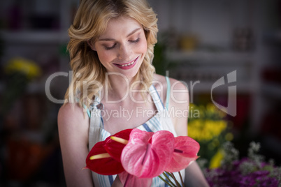 Female florist holding flowers in flower shop
