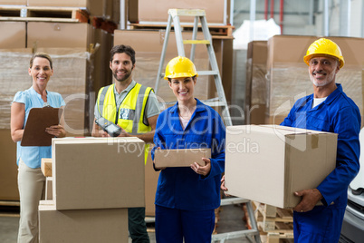 Smiling workers carrying boxes