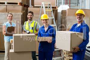 Smiling workers carrying boxes