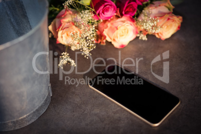 Pink roses and smartphone on the table