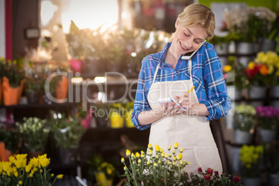 Female florist taking an order on mobile phone