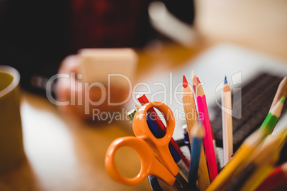 Color pencils and scissor in pen holder