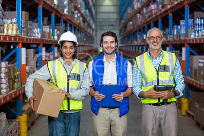 Warehouse workers looking at camera in warehouse