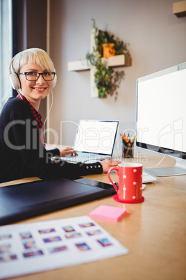 Female graphic designer working on computer and laptop