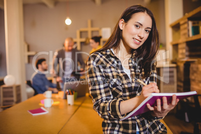 Graphic designer making notes in her diary