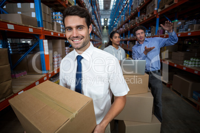 Focus of manager holding cardboard box and smiling