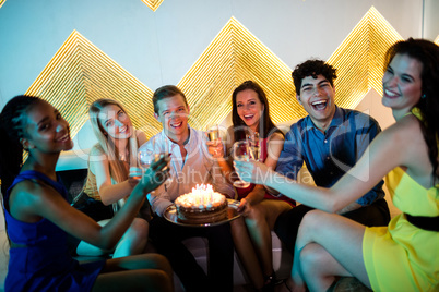 Group of smiling friends having a glass of champagne while celeb