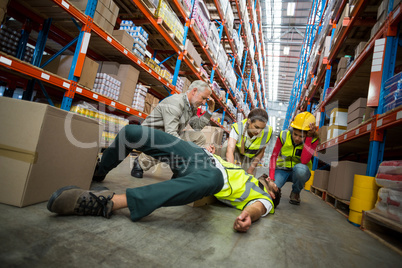 Workers taking care about their colleague lying on the floor
