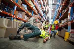 Workers taking care about their colleague lying on the floor