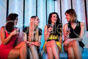 Smiling friends interacting each other while having wine