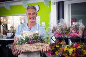 Male florist carrying plant pot in wicker basket