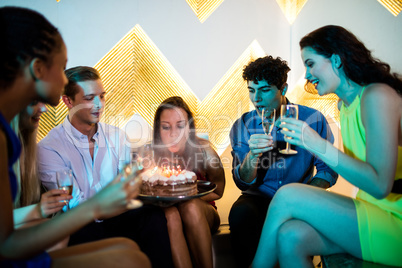 Group of smiling friends having a glass of champagne while celeb