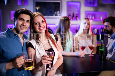 Smiling friends having a glass of wine and beer in bar