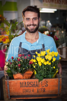 Male florist holding crate of flower bouquet