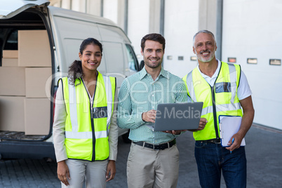 Manager and workers are smiling and posing face to the camera