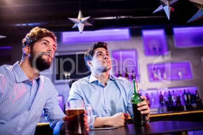Friends sitting at bar counter and having beer