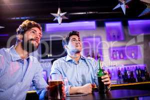 Friends sitting at bar counter and having beer